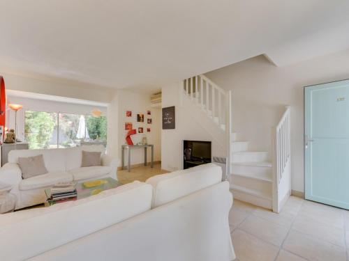 a white living room with a white couch and stairs at Holiday Home Les Parcs de Gassin-9 by Interhome in Saint-Tropez