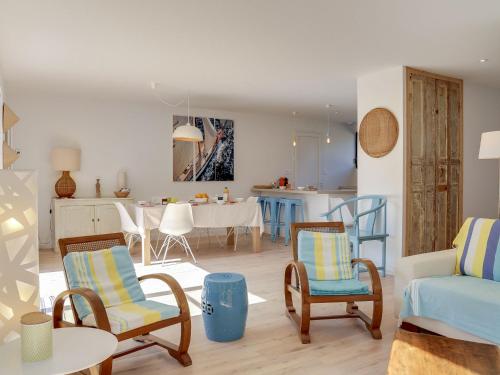 ein Wohnzimmer mit Stühlen und einem Tisch sowie eine Küche in der Unterkunft Holiday Home Les Pins du Rohu by Interhome in Saint-Julien