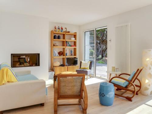 ein Wohnzimmer mit einem Sofa und einem TV in der Unterkunft Holiday Home Les Pins du Rohu by Interhome in Saint-Julien