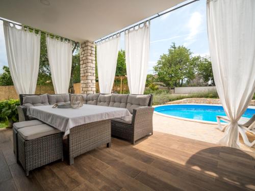a patio with a table and chairs and a pool at Holiday Home Ofelia by Interhome in Buroli