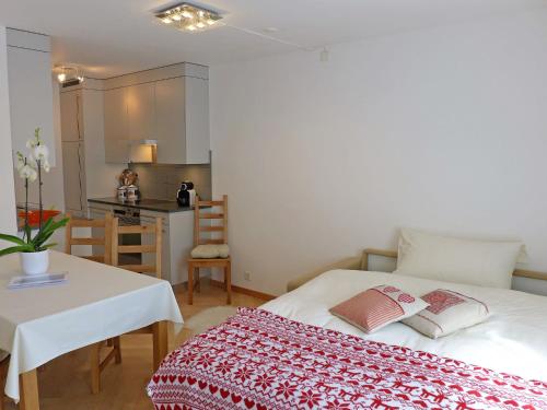 um quarto com uma cama, uma mesa e uma cozinha em Apartment Chesa Sur Ova 21 by Interhome em St. Moritz