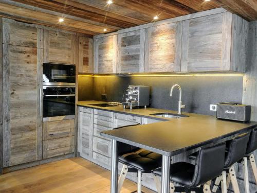 a kitchen with wooden cabinets and a table with chairs at Apartment Les Grandes Platières-23 by Interhome in Tignes