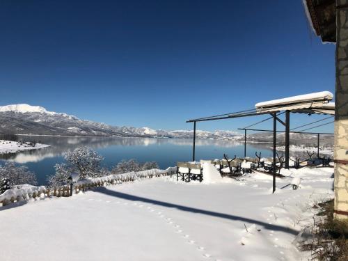 a winter view of a lake with snow on the ground at Ξενώνας Παρατηρητήριο Υπερώον in Ágios Athanásios