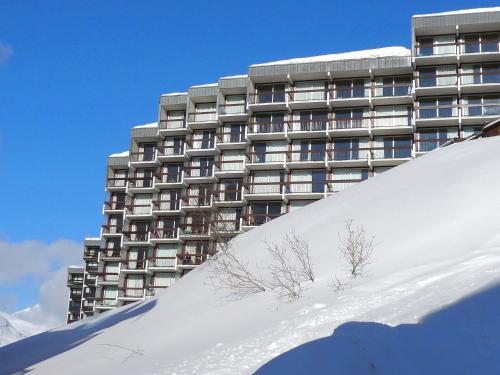 un grand bâtiment devant un bâtiment recouvert de neige dans l'établissement Studio Grande Platières II by Interhome, à Tignes