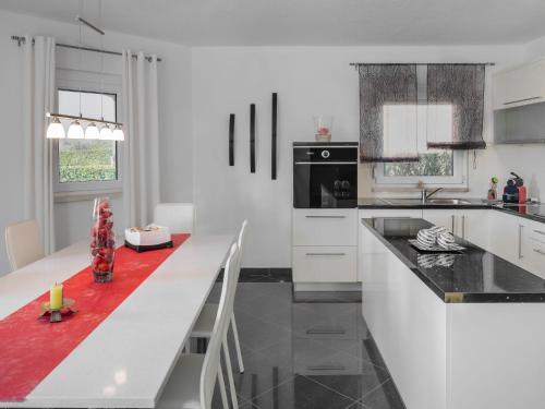 a white kitchen with a black and white counter top at Apartment Lucia-1 by Interhome in Kmeti