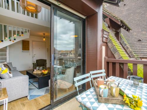 un patio avec une table et des chaises sur un balcon dans l'établissement Apartment Le Fairway-5 by Interhome, à Deauville