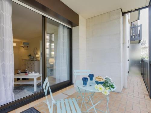 un patio avec une table et des chaises sur un balcon dans l'établissement Apartment l'Hermitage-2 by Interhome, à Deauville
