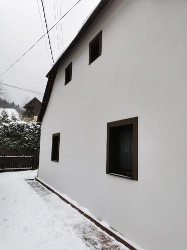 a white building with a tv on the side of it at Chalupa U Potoka in Staré Hory