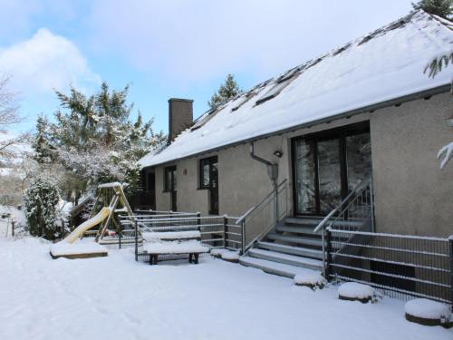 a house with a snow covered porch with a slide at Apartment Eifelnatur - Haus 2-2 by Interhome in Immerath