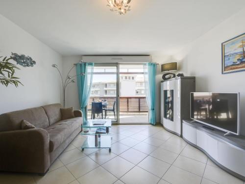 uma sala de estar com um sofá e uma televisão em Apartment Beau Rivage-3 by Interhome em Cavalaire-sur-Mer