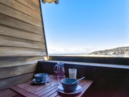 une table avec deux tasses et un vase sur un balcon dans l'établissement Studio Les Marinas-12 by Interhome, à Deauville