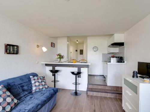 un salon avec un canapé bleu et une cuisine dans l'établissement Studio Les Marinas-12 by Interhome, à Deauville