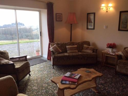 a living room with a couch and a table at Holiday Home Wester Riechip by Interhome in Dunkeld
