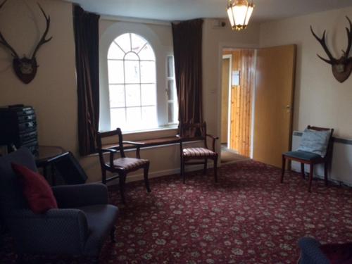 a living room with chairs and a table and a window at Holiday Home Wester Riechip by Interhome in Dunkeld
