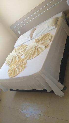 a white bed with white sheets and pillows at Vilas na Praia Residence Canoa Quebrada CE Apartamento PÉ NA AREIA superior com 2 suítes, vista para a Praia e Dunas e com privacidade total in Canoa Quebrada