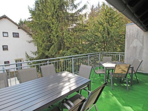 um pátio com mesas e cadeiras numa varanda em Apartment Eifelnatur - Haus 2-3 by Interhome em Immerath