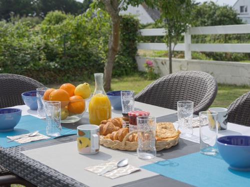 - une table avec un bol de pain et des oranges dans l'établissement Holiday Home Maison de Kerfilly by Interhome, à Quiberon