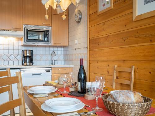 a kitchen with a table with plates and wine glasses at Studio Les Grandes Platières-26 by Interhome in Tignes