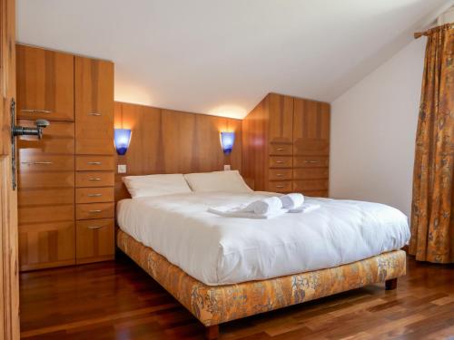 una camera con un grande letto e armadi in legno di Apartment Chesa Polaschin E - E21 - Sils by Interhome a Sils Maria