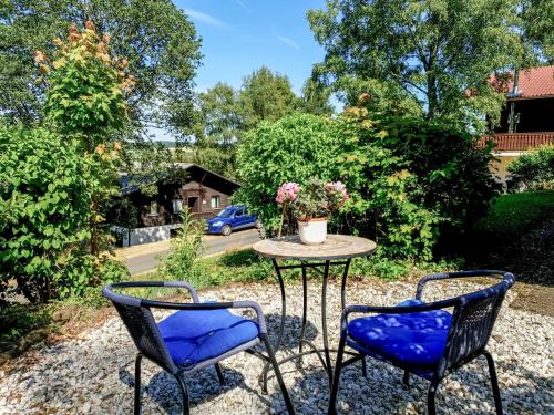 two chairs and a table with a vase on it at Apartment Ferienpark Himmelberg-4 by Interhome in Thalfang
