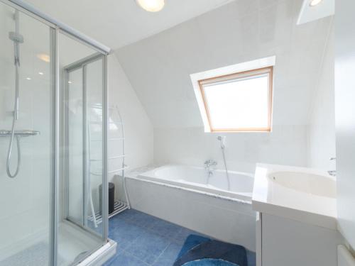 a white bathroom with a tub and a sink at Apartment Goldsands II 402 by Interhome in De Haan