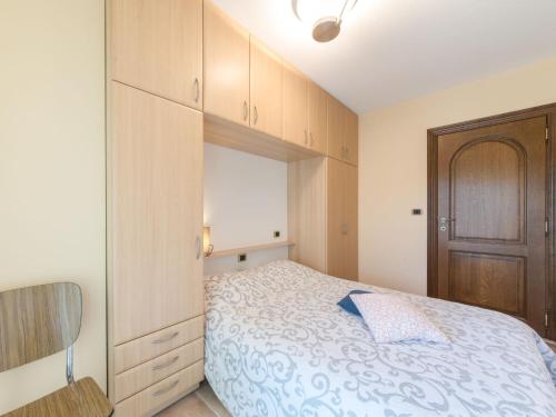 a bedroom with a bed and a wooden cabinet at Apartment Goldsands II 101 with garage by Interhome in De Haan