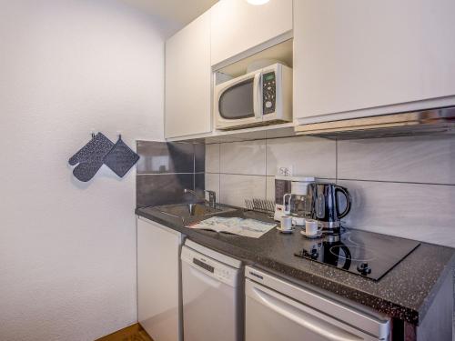 une petite cuisine avec un évier et un micro-ondes dans l'établissement Studio Rond Point des Pistes - Val Claret-12 by Interhome, à Tignes