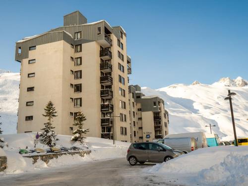 un bâtiment dans la neige avec des voitures garées devant dans l'établissement Apartment Le Schuss - Val Claret-6 by Interhome, à Tignes