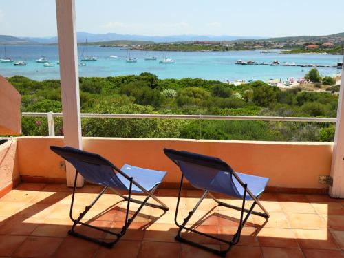 two chairs on a balcony with a view of the water at Apartment Vista Playa 1 by Interhome in Golfo Aranci