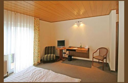 Ronneburg的住宿－Hotel Zur Krone，一间卧室配有一张桌子、一台电脑和一把椅子