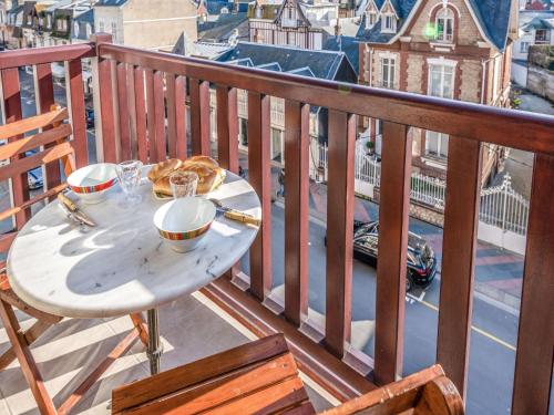 une table avec une assiette de nourriture sur un balcon dans l'établissement Apartment Le Hoc-1 by Interhome, à Deauville