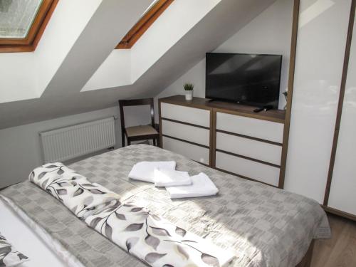 a bedroom with a bed and a flat screen tv at Chalet Srub Kuří by Interhome in Benešov nad Černou