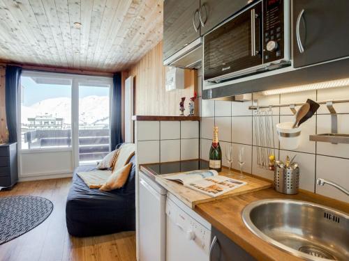 a kitchen with a sink and a couch in a room at Studio Le Curling A-21 by Interhome in Tignes
