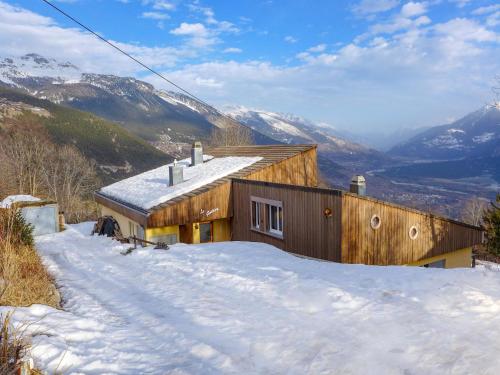 a house in the snow with mountains in the background at Chalet Maison Le Fontany by Interhome in Randogne