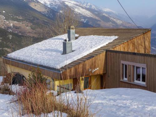 a house with snow on the roof with mountains in the background at Chalet Maison Le Fontany by Interhome in Randogne
