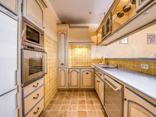 a kitchen with white cabinets and yellow tiles at Apartment Boulevard Louis Blanc-1 by Interhome in Saint-Tropez