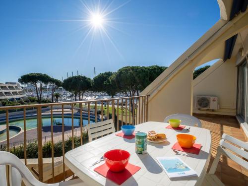 d'une table et de chaises sur un balcon avec vue sur la piscine. dans l'établissement Apartment Le Grand Galion-2 by Interhome, au Grau-du-Roi