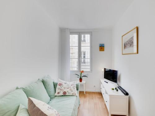 un salon avec un canapé vert et une télévision dans l'établissement Apartment Carnot by Interhome, à Trouville-sur-Mer