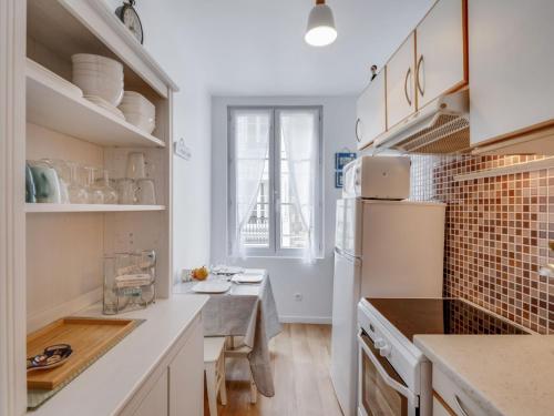 cocina con armarios blancos y nevera blanca en Apartment Carnot by Interhome, en Trouville-sur-Mer
