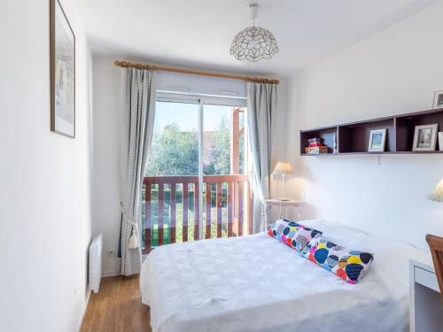 a bedroom with a bed and a window with a balcony at Apartment Domaine de Clairefontaine-3 by Interhome in Deauville