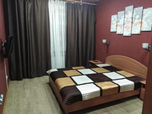 a bedroom with a bed with a black and white blanket at 2- х комнатные апартаменты на Олимпийской Зима-Лето in Kirovsk