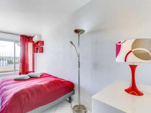 - une chambre avec un lit rouge et une fenêtre dans l'établissement Apartment Les Jardins du Port-10 by Interhome, au Grau-du-Roi