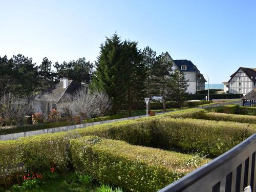 un jardin avec des haies et des fleurs sur une clôture dans l'établissement Apartment Les Terrasses de Tourgeville-3 by Interhome, à Tourgéville