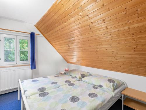 a bed in a room with a wooden ceiling at Holiday Home Holiday Hill 29 by Interhome in Lauterwasser