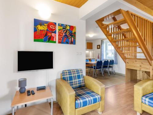 a living room with a tv and a couch and a chair at Holiday Home Holiday Hill 51 by Interhome in Lauterwasser