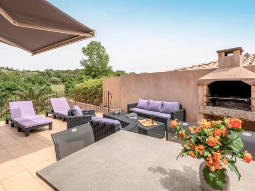 un patio avec une table, des chaises et une cheminée dans l'établissement Apartment Muratello by Interhome, à Porto-Vecchio