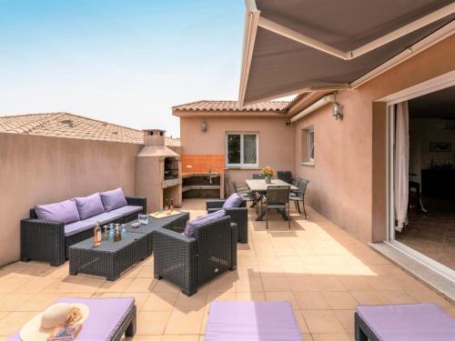 d'une terrasse avec un canapé, des chaises et une table. dans l'établissement Apartment Muratello by Interhome, à Porto-Vecchio