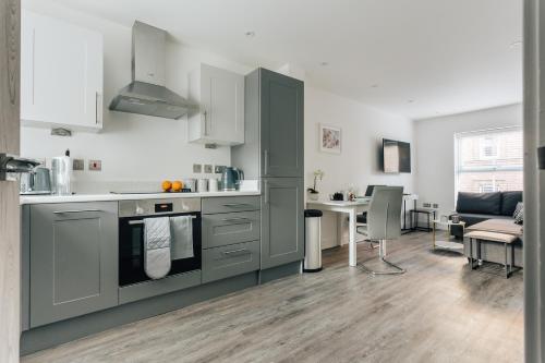 a kitchen with gray cabinets and a table with a dining room at Central 2 double bedroom flat with parking in Bournemouth