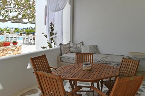 Margarita Studios Ambelas في أمبيلاس: طاولة وكراسي في غرفة معيشة مع أريكة