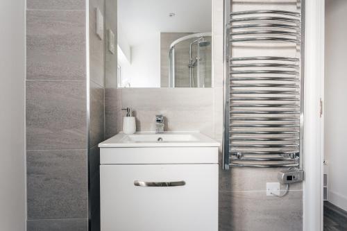 a white bathroom with a sink and a mirror at Central 2 double bedroom flat with parking in Bournemouth